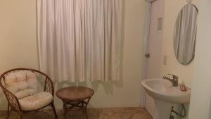 a bathroom with a sink and a chair and a shower at Hotel Magic Tropical in Boca Chica