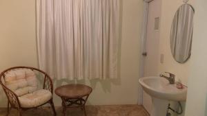 y baño con lavabo, silla y ducha. en Hotel Magic Tropical, en Boca Chica