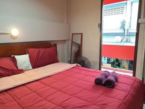 a bedroom with a red bed with a red blanket at SMILE HOME GUESTHOUSE in Rayong