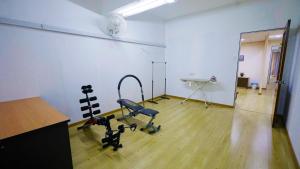 a room with a gym with a chair and a desk at Pak Long Shoplot Homestay in Shah Alam