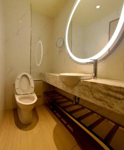 a bathroom with a sink and a toilet and a mirror at 26 Inn in Yilan City