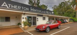 a red car parked in front of a motel at Atherton Hinterland Motel in Atherton