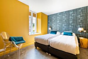 1 dormitorio con 1 cama grande y 1 silla en Gîtes Openroc - Vue imprenable sur Colmar, en Trois-Épis