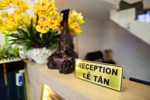 a yellow sign on a counter with flowers on it at Hoa Cát Hotel in Quy Nhon