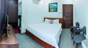 1 dormitorio con 1 cama y TV en Hoa Cát Hotel, en Quy Nhon