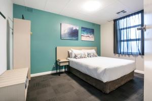
a bedroom with a bed and a desk at Nightcap at Watermark Glenelg in Adelaide
