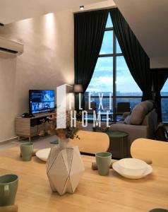 a living room with a couch and a table with a television at NETFLIX-Pinnacle PJ, Fantastic City View, 1-6 Guests Designed Duplex Home by Flexihome-MY in Petaling Jaya