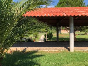 un pavillon avec un toit rouge dans un parc dans l'établissement Cabaña Tequila Pueblo Mágico 1, à Tequila