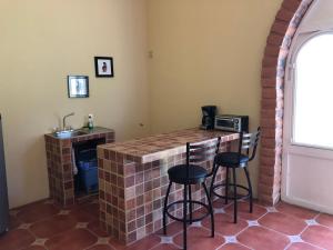 - une cuisine avec un bar en briques, des tabourets et un évier dans l'établissement Cabaña Tequila Pueblo Mágico 1, à Tequila