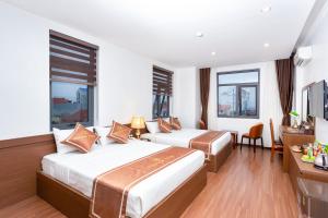 2 łóżka w pokoju hotelowym z oknami w obiekcie Victoria Hotel Ninh Binh w mieście Ninh Binh