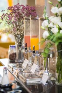 une table avec des vases de fleurs et des verres de jus d'orange dans l'établissement Danly Hotel, à Hanoï
