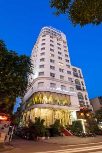 a tall white building with a lot of windows at Danly Hotel in Hanoi