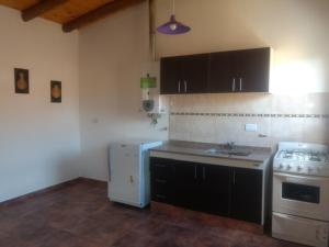Una cocina con gabinetes negros y un refrigerador blanco. en View Point Apart Nogal, en Villa Giardino 17 fotos más