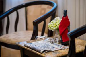 a table with a bottle of wine and a vase of flowers at Danly Hotel in Hanoi