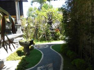 a garden with a stone path leading to a house at Dika Homestay in Sidemen