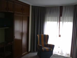 ein Schlafzimmer mit einem Bett, einem Stuhl und einem Fenster in der Unterkunft Hotel Alemar in Somo + 17 Fotos