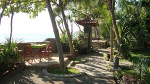 un patio con mesa y sillas junto al océano en Villa Selina, en Tejakula