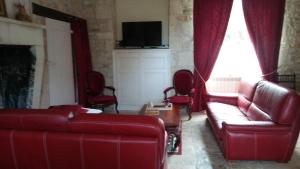 ein Wohnzimmer mit einem roten Sofa und roten Stühlen in der Unterkunft Manoir De Vilaines in Varennes