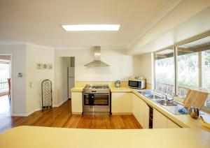 a kitchen with a sink and a stove top oven at Tegwan's Nest Holiday Home in Balingup