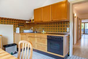 a kitchen with wooden cabinets and a stove at stuub simonswinkel in Friedenweiler