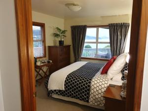 Schlafzimmer mit einem Bett und einem Fenster in der Unterkunft Tui2 Macandrew Bay in Dunedin