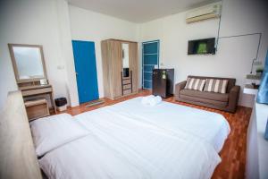 a bedroom with a large white bed and a couch at Hip Home at Hod in Hot