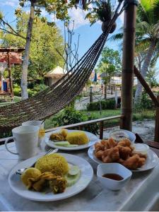 uma mesa com pratos de comida numa rede de descanso em Mook Montra Resort Sea Front em Ko Mook