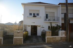 a white house with a door and a balcony at AirPorto Hostel in Maia