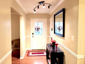 a hallway with a door and a table and a mirror at The Oasis in Clinton