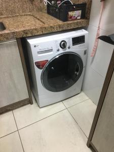 a white washing machine in the corner of a kitchen at Apartamento 601 3 Dormitórios in Torres