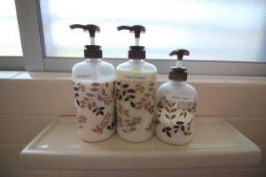 drei Flaschen Seife stehen auf einem Regal in einem Badezimmer in der Unterkunft 沖縄ライフインゼファー Okinawa Totoro House in Tōbaru + 34 Fotos