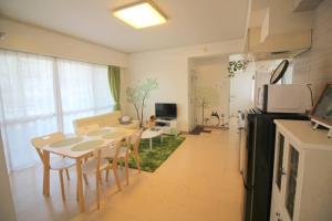 a kitchen and living room with a table and chairs at 沖縄ライフインゼファー j28 in Tōbaru