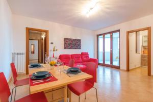 salon z czerwoną kanapą i stołem w obiekcie GoodStay Archimede Apartment w mieście Lecce