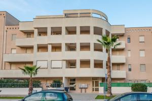 budynek z dwoma palmami przed nim w obiekcie GoodStay Archimede Apartment w mieście Lecce