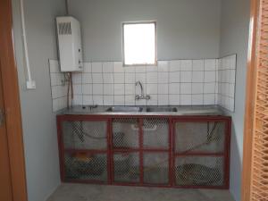 a kitchen with a sink and a counter with chickens in it at Old Bridge Camping in Maltahöhe