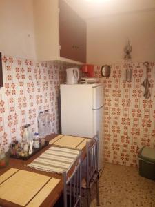 cocina con nevera blanca y mesa con encimera en Quiet - Comfortable apartment 33sqm Pagrati Athens, en Atenas