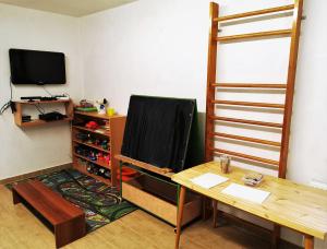 Zimmer mit einem Schreibtisch, einem TV und einem Tisch in der Unterkunft Apartmány Nad řekou in Svoboda nad Úpou