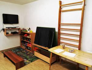 a room with a desk and a television and a table at Apartmány Nad řekou in Svoboda nad Úpou