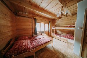 a bedroom with two beds in a log cabin at Chata MTB in Kościelisko