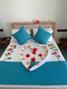 ein Herz aus Blumen auf einem Bett in der Unterkunft Ithaa Thoddoo Inn in Thoddoo-Atoll