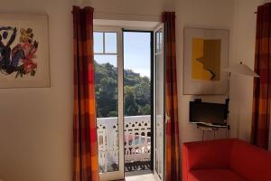 sala de estar con una puerta corredera de cristal que da a un balcón en Raposeira de São João, the feeling of peace, space and quiet, Whole villa is yours, en Fajã da Ovelha