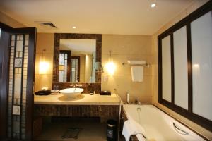 
a bathroom with a tub, sink and mirror at Dong Fang Hotel Guangzhou in Guangzhou
