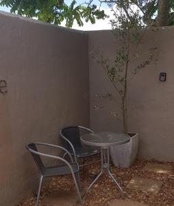 a table and two chairs next to a tree at El Shaddai in Darling +1 photo