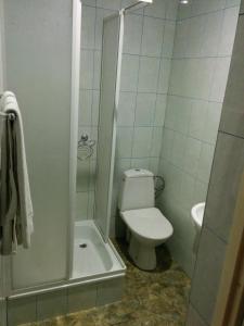 a white bathroom with a toilet and a shower at Kaiser Hotel in Chernivtsi