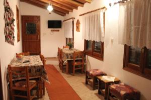 a dining room with two tables and chairs in a room at Villa Horizon in Tsagarada