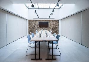 a conference room with a long table and chairs at INNSiDE by Meliá Zaragoza in Zaragoza