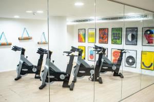 a gym with several tread machines in a room with a mirror at INNSiDE by Meliá Zaragoza in Zaragoza
