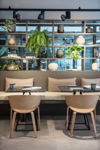 a restaurant with two tables and chairs and plants at INNSiDE by Meliá Zaragoza in Zaragoza