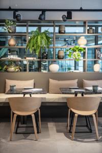 a restaurant with two tables and chairs and plants at INNSiDE by Meliá Zaragoza in Zaragoza +37 photos