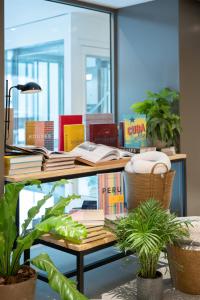 a desk with books on top of it with plants at INNSiDE by Meliá Zaragoza in Zaragoza